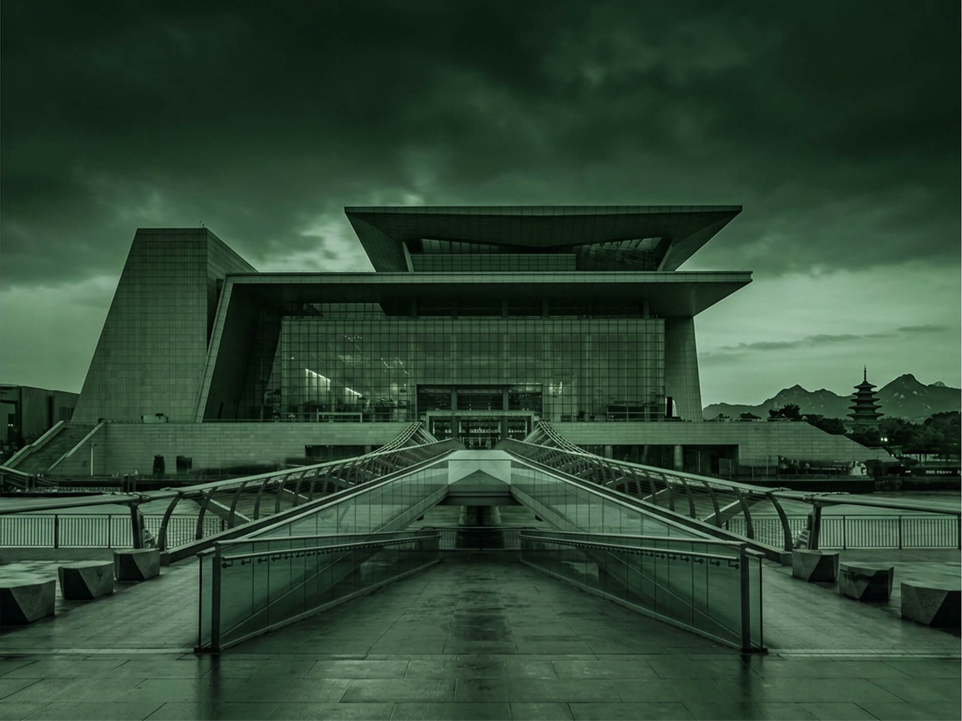 La fachada moderna del Museo Nacional de Corea en Seúl, rodeada de jardines abiertos, con la montaña Namsan al fondo